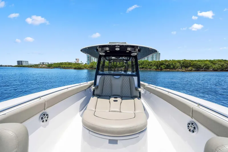 Slide: The Image of 2024 Sportsman Open 352 Center Console boat on calm water, clear sky background. - 33
