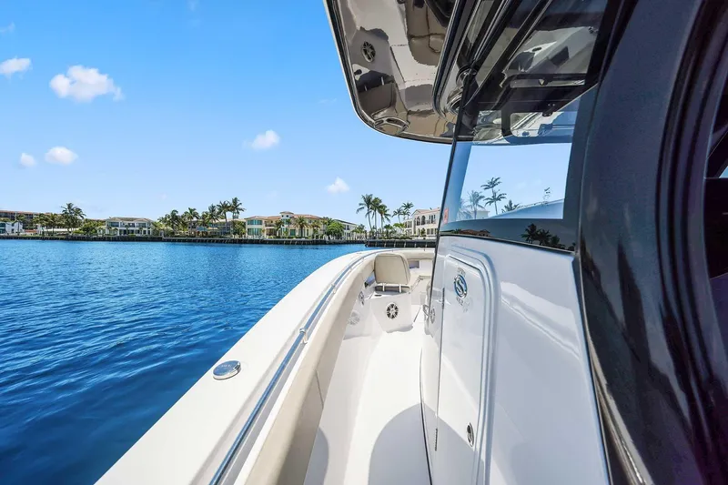 Slide: The Image of 2024 Sportsman Open 352 Center Console boat on serene water with luxury homes in background. - 34
