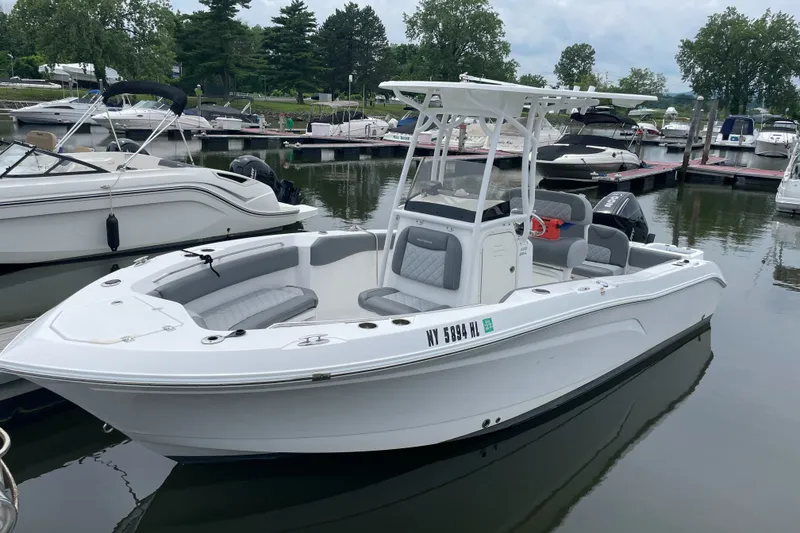 Slide: The Image of 2024 NauticStar 222L Offshore boat docked in a marina, featuring sleek design and modern amenities. - 2