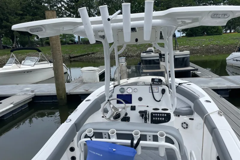 Slide: The Image of 2024 NauticStar 222L Offshore boat docked, featuring a modern helm and spacious seating. - 4