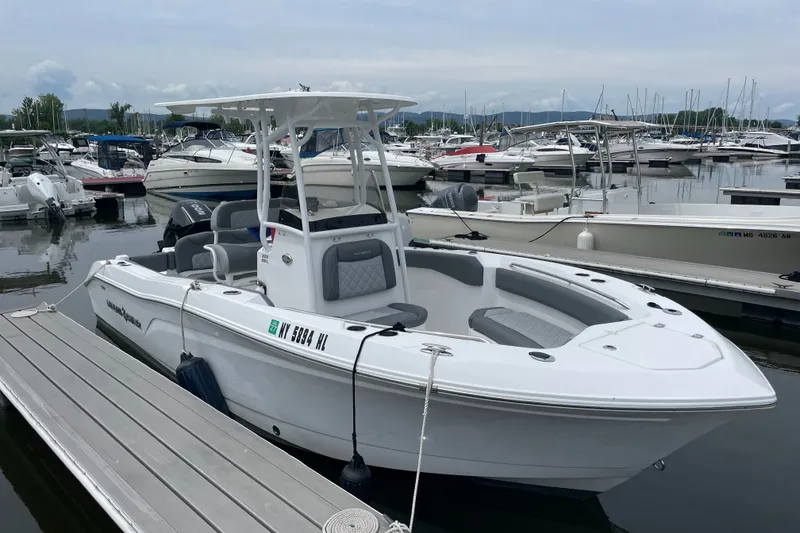 The Image of 2024 NauticStar 222L Offshore boat docked at marina, surrounded by other vessels. - 1