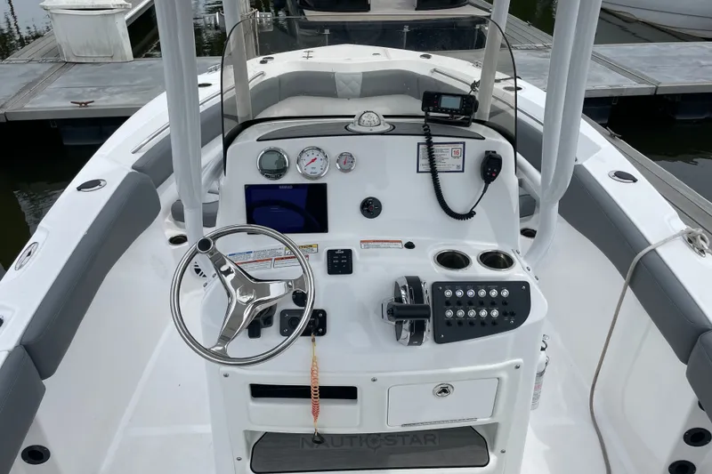 Slide: The Image of 2024 NauticStar 222L Offshore boat dashboard with steering wheel and controls. - 6