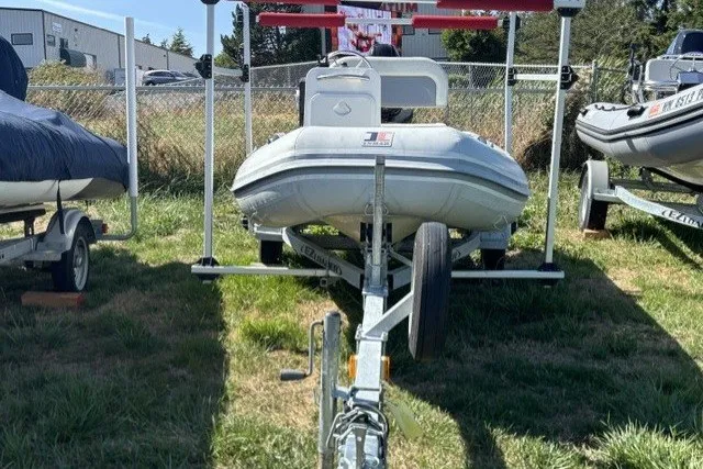 Slide: The Image of 2019 Inmar 330R-YS inflatable boat on trailer, parked outdoors on grass. - 2