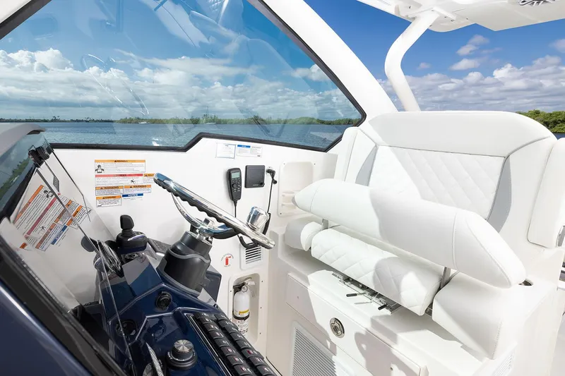 Slide: The Image of Manufacturer Provided Image: 2025 Pursuit DC 326 Dual Console boat interior with steering wheel and white seating. - 9