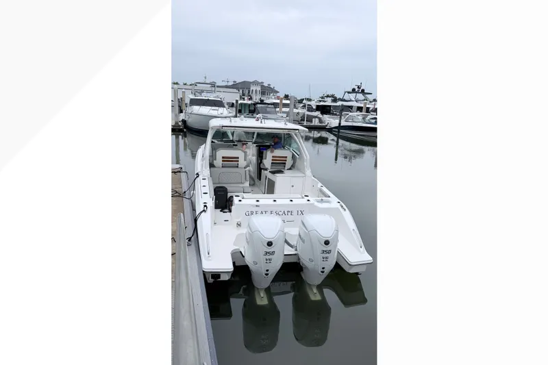 Slide: The Image of 2025 Pursuit DC 326 Dual Console boat docked with twin 350 engines. - 2