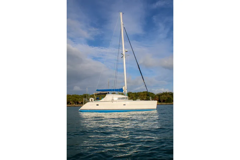 Slide: The Image of 2001 Lagoon 410 catamaran sailing on calm waters under a blue sky. - 41