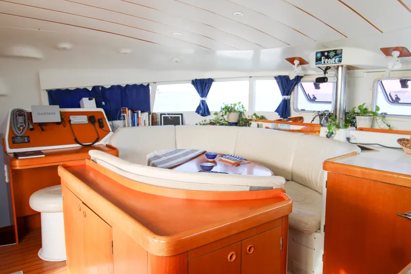 Slide: The Image of Interior of a 2001 Lagoon 410 catamaran with cozy seating and navigation equipment. - 47