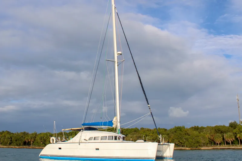 Slide: The Image of 2001 Lagoon 410 catamaran sailing on calm waters under a cloudy sky. - 44