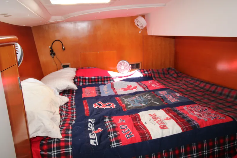 Slide: The Image of Cozy cabin bedroom in 2001 Lagoon 410 catamaran with sports-themed bedding. - 62