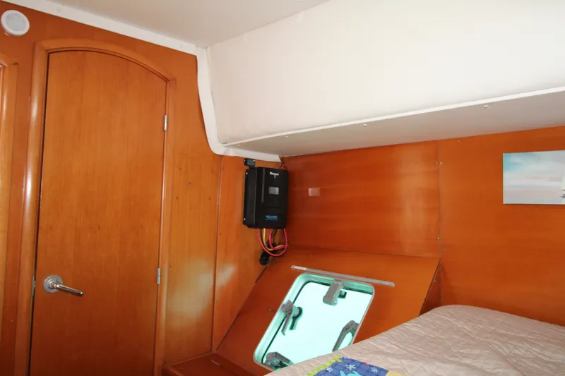 Slide: The Image of Interior cabin of 2001 Lagoon 410 catamaran with wooden finish and porthole. - 32