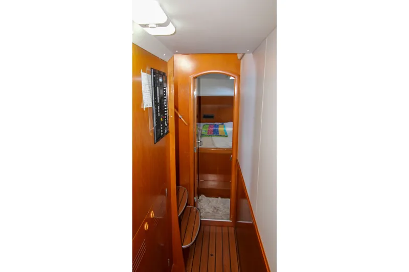 Slide: The Image of Narrow hallway inside 2001 Lagoon 410 yacht, featuring wooden paneling and cozy cabin entrance. - 34