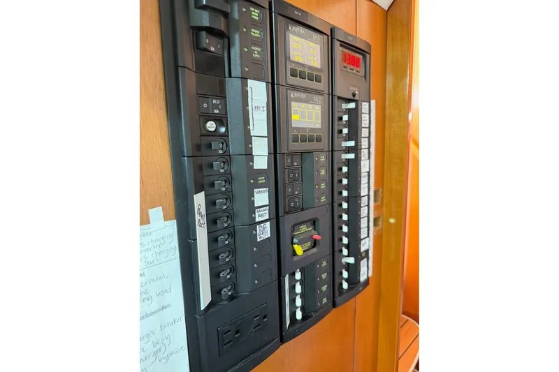 Slide: The Image of Electrical panel on a 2001 Lagoon 410 catamaran, featuring switches and meters. - 69