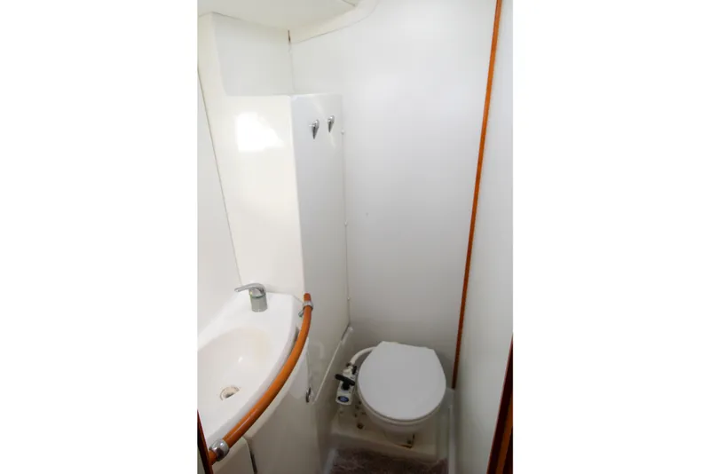 Slide: The Image of Compact bathroom in a 2001 Lagoon 410 yacht, featuring a toilet and sink. - 33