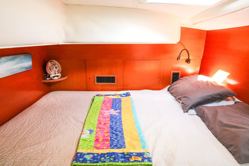 Slide: The Image of Cozy cabin interior of 2001 Lagoon 410 catamaran with colorful bedding and wooden accents. - 30