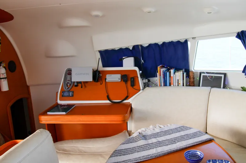 Slide: The Image of Interior of a 2001 Lagoon 410 yacht with navigation equipment and cozy seating area. - 52