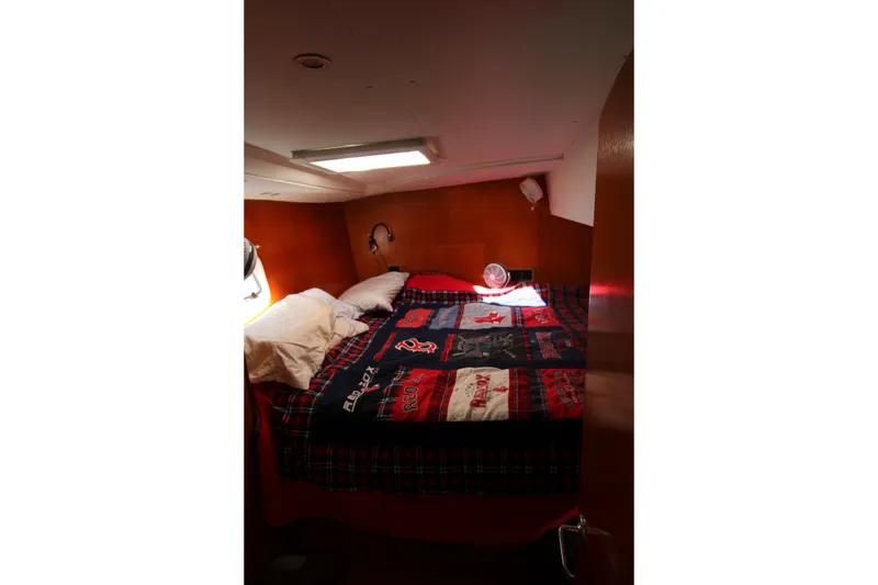 Slide: The Image of Cozy cabin interior of 2001 Lagoon 410 catamaran with colorful bedding and pillows. - 60
