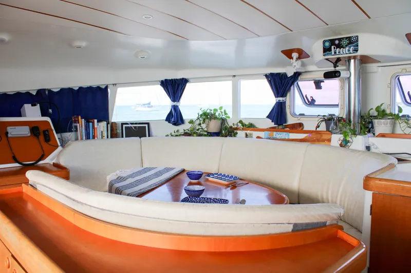 Slide: The Image of Interior of a 2001 Lagoon 410 catamaran with cozy seating and nautical decor. - 56