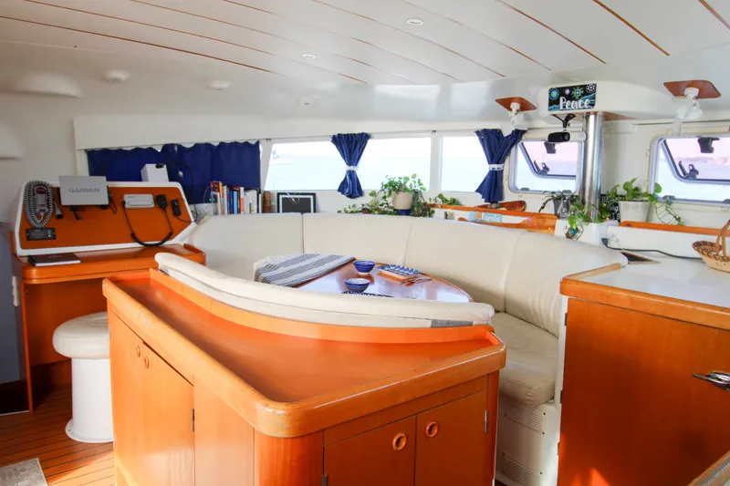 Slide: The Image of Interior of a 2001 Lagoon 410 catamaran with cozy seating and navigation equipment. - 48