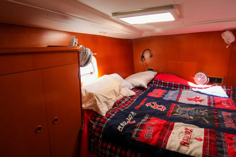 Slide: The Image of Cozy cabin interior of 2001 Lagoon 410 catamaran with colorful bedding and wooden cabinetry. - 61