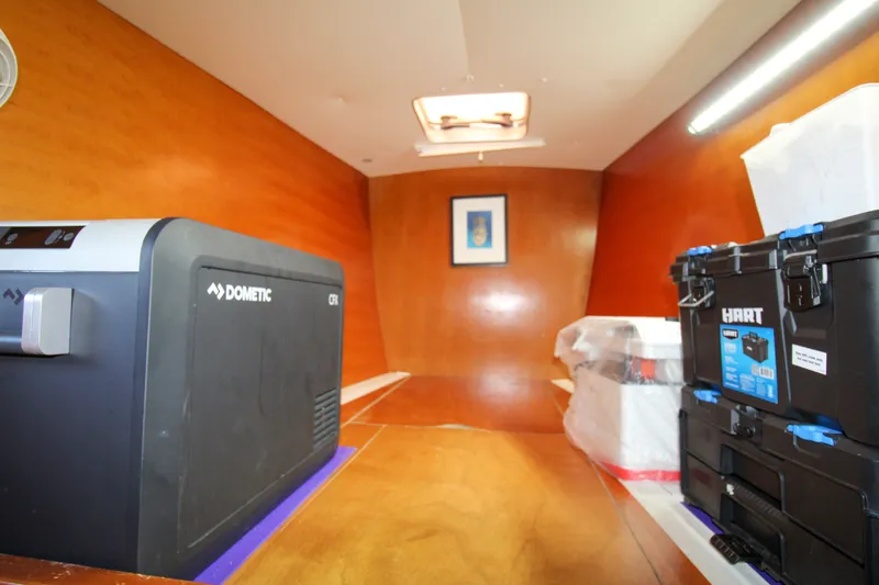 Slide: The Image of Interior of a 2001 Lagoon 410 boat with storage boxes and a Dometic cooler. - 38