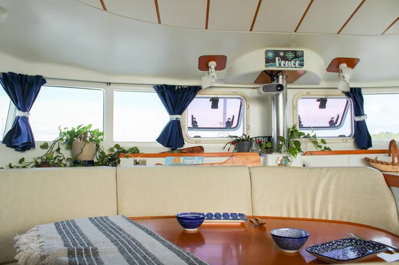 Slide: The Image of Interior of a 2001 Lagoon 410 catamaran with cozy seating and nautical decor. - 57
