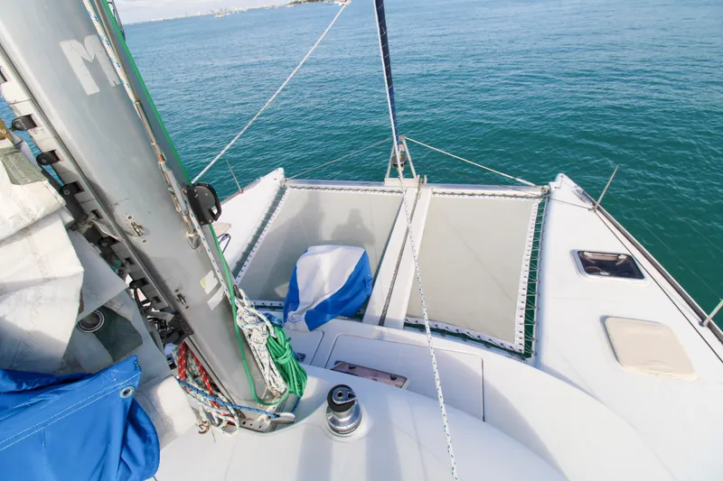 Slide: The Image of 2001 Lagoon 410 catamaran deck view with sails and ocean backdrop. - 26