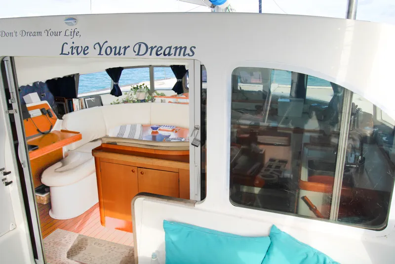 Slide: The Image of Interior of a 2001 Lagoon 410 catamaran with cozy seating and nautical decor. - 49