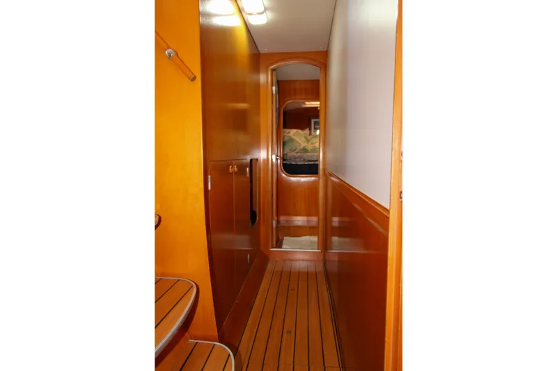Slide: The Image of Interior hallway of a 2001 Lagoon 410 catamaran with wooden paneling and flooring. - 63