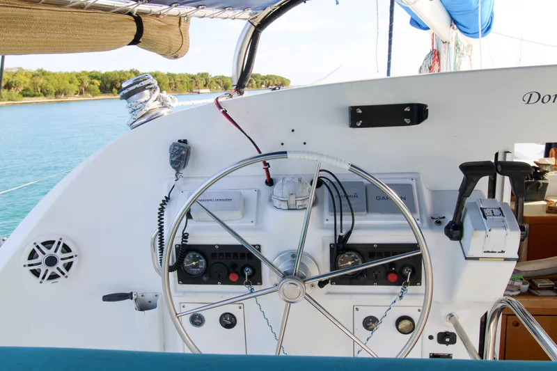 Slide: The Image of Steering wheel and controls of a 2001 Lagoon 410 catamaran, with ocean view. - 29