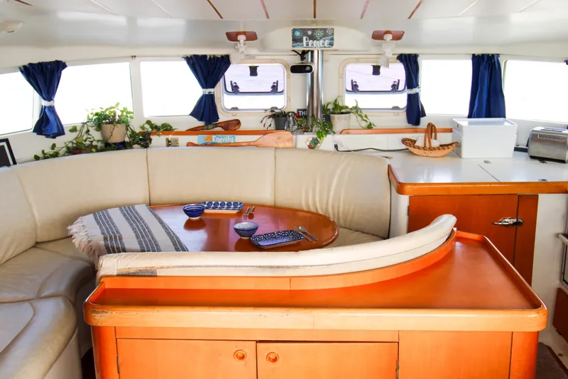 Slide: The Image of Interior of a 2001 Lagoon 410 catamaran with cozy seating and nautical decor. - 46