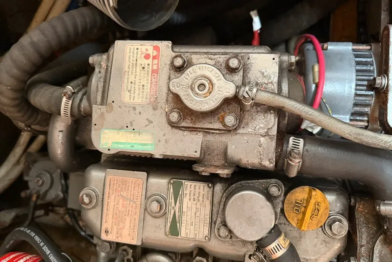 Slide: The Image of Engine components of a 2001 Lagoon 410 catamaran, featuring hoses and warning labels. - 67