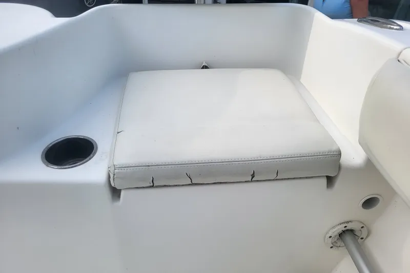 Slide: The Image of Cobia 217 Center Console 2012 boat seat with cup holder and visible wear. - 29