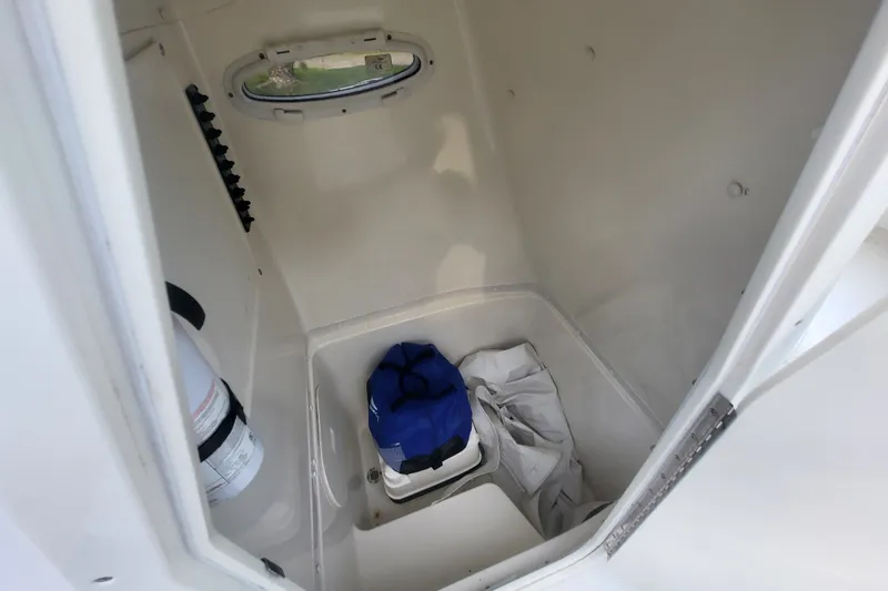 Slide: The Image of Interior storage compartment of 2012 Cobia 217 Center Console boat with gear and fire extinguisher. - 30