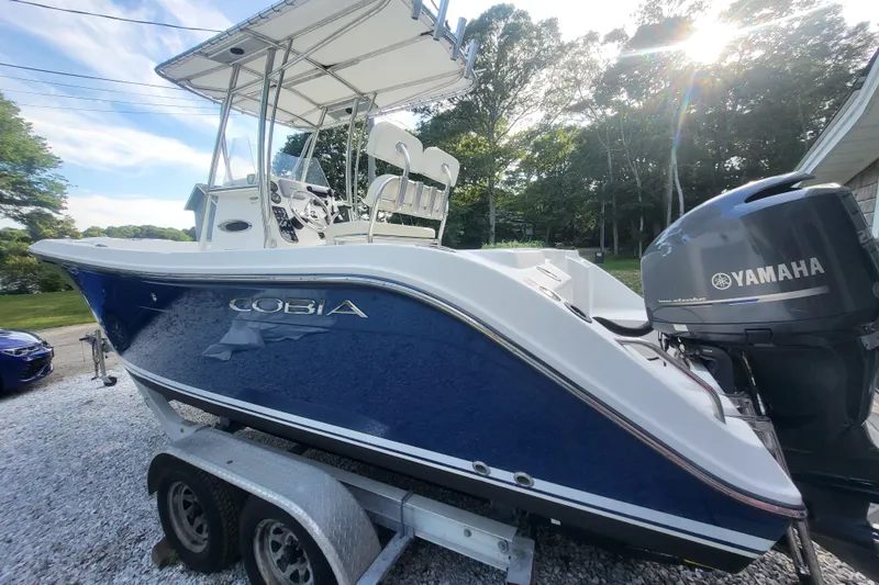 The Image of 2012 Cobia 217 Center Console boat with Yamaha engine on trailer. - 0
