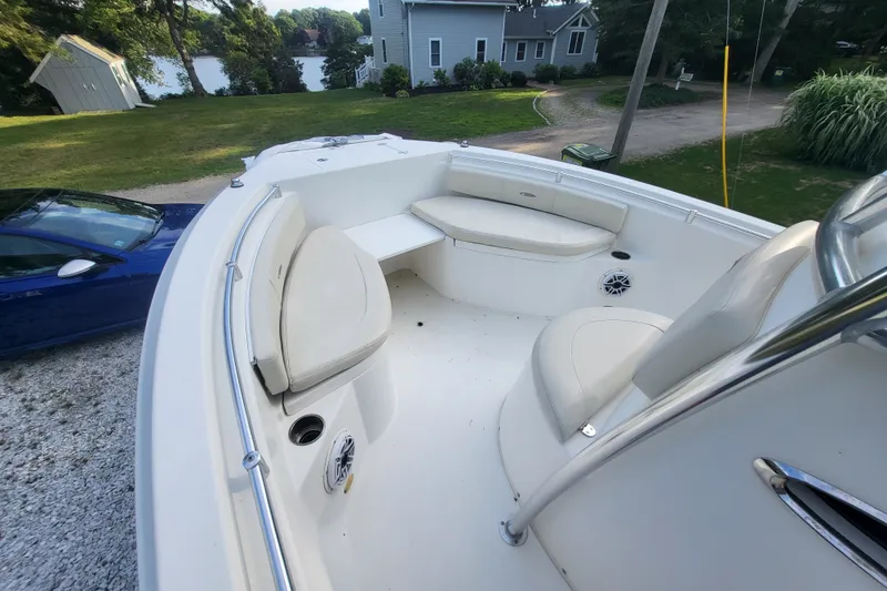 Slide: The Image of 2012 Cobia 217 Center Console boat interior with white seating and scenic background. - 31