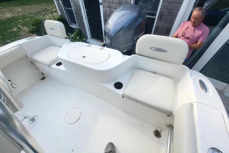 Slide: The Image of 2012 Cobia 217 Center Console boat interior with seating and Yamaha engine. - 10