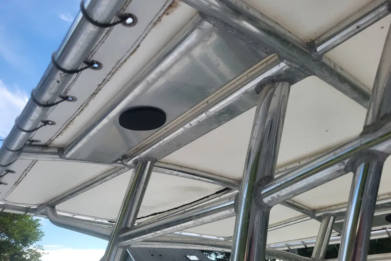 Slide: The Image of T-top structure of a 2012 Cobia 217 Center Console boat under a clear sky. - 26