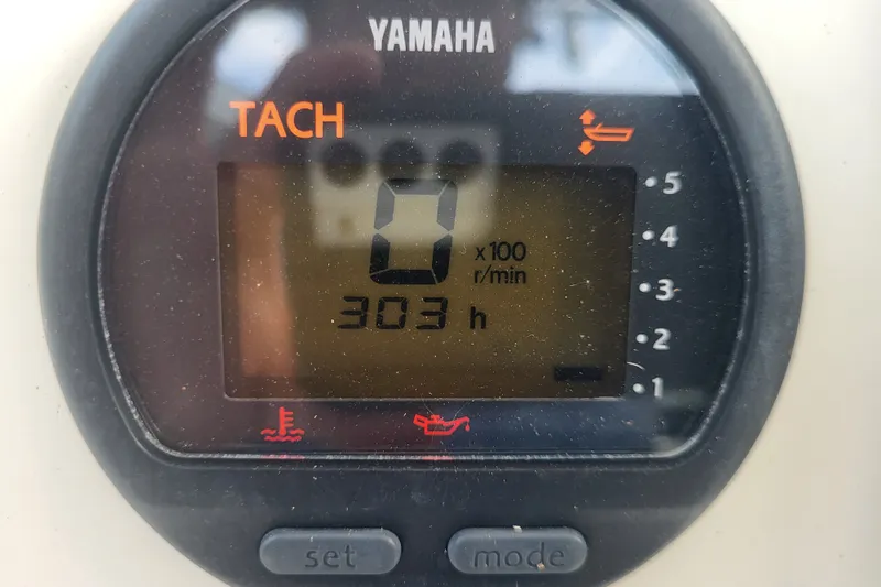 Slide: The Image of Yamaha tachometer displaying 303 hours on a 2012 Cobia 217 Center Console boat. - 25