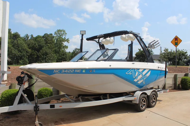Slide: The Image of 2022 ATX Surf Boats 22 Type-S on trailer, blue and white design, parked outdoors. - 6