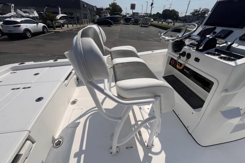 Slide: The Image of 2023 BlackJack 256 Bay boat interior with helm and seating in a dealership lot. - 7