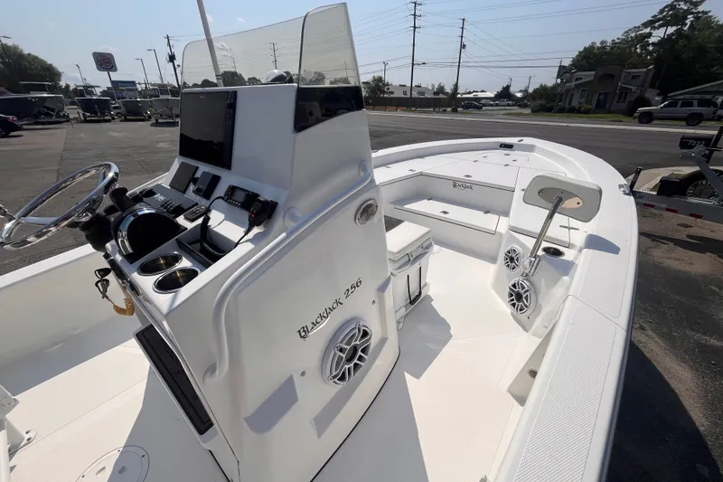 Slide: The Image of 2023 BlackJack 256 Bay boat interior with steering console and seating area. - 9