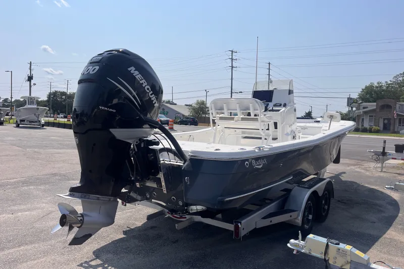 Slide: The Image of 2023 BlackJack 256 Bay boat with Mercury engine on trailer in parking lot. - 5