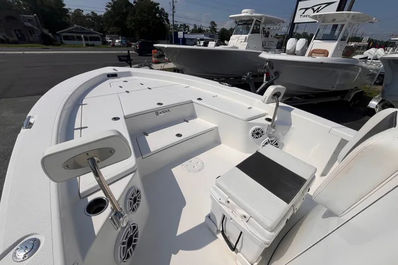 Slide: The Image of 2023 BlackJack 256 Bay boat interior with seating and storage, displayed outdoors. - 15