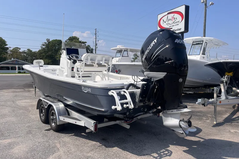 Slide: The Image of 2023 BlackJack 256 Bay boat with Mercury 400 engine on a trailer at a marina. - 3