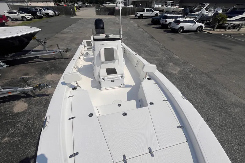 Slide: The Image of 2023 BlackJack 256 Bay boat in a marina parking lot, showcasing sleek design and spacious deck. - 11