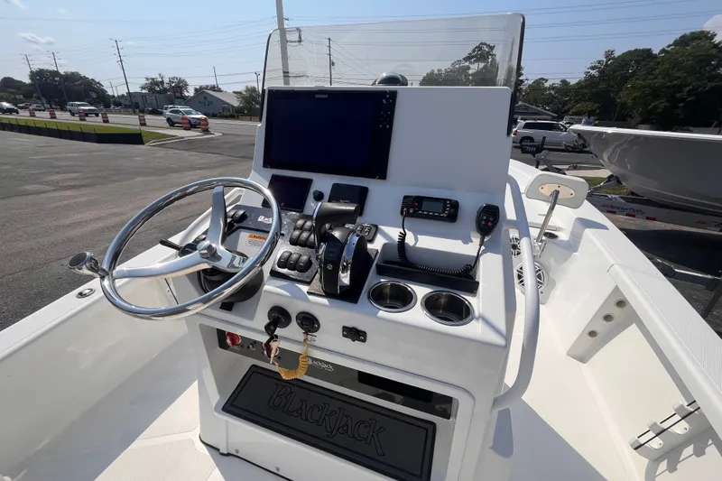 Slide: The Image of 2023 BlackJack 256 Bay boat console with steering wheel, electronics, and cup holders. - 8