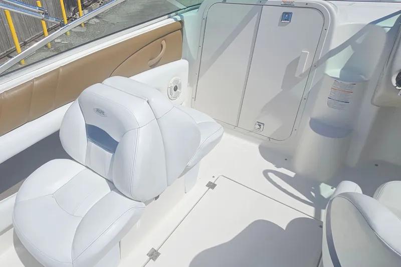 Slide: The Image of 2003 Chaparral 215 SS boat interior with white seating and storage compartment. - 12