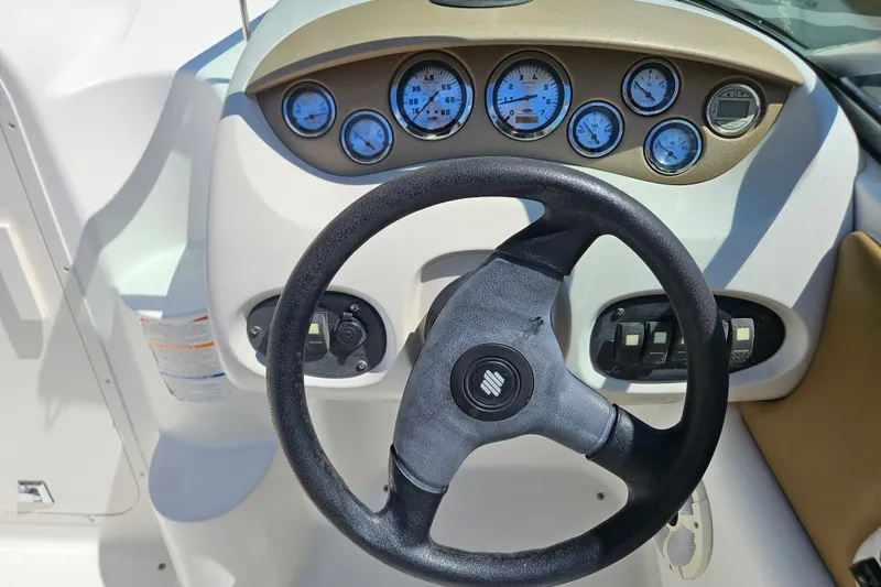 Slide: The Image of Steering wheel and dashboard of a 2003 Chaparral 215 SS boat, featuring multiple gauges. - 17