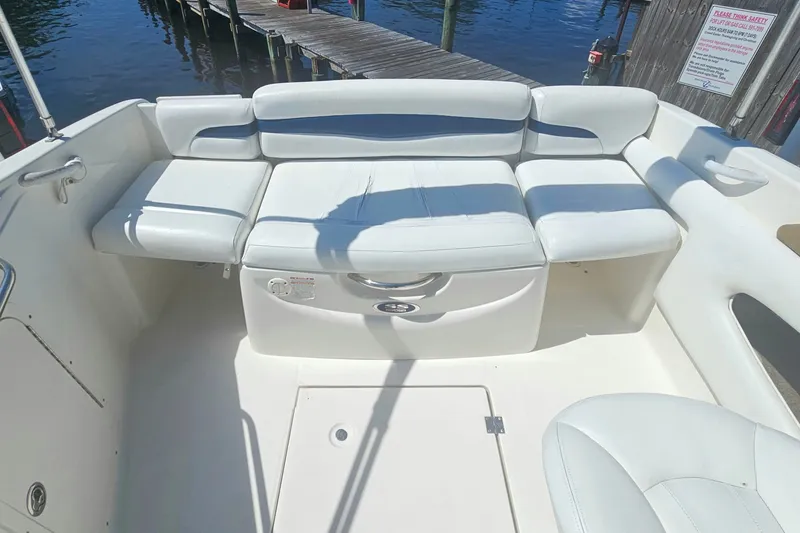 Slide: The Image of 2003 Chaparral 215 SS boat interior with white seating and dock view. - 11