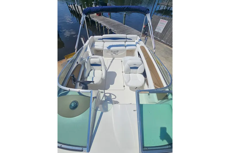 Slide: The Image of 2003 Chaparral 215 SS boat interior with seating and steering wheel, docked by the water. - 20